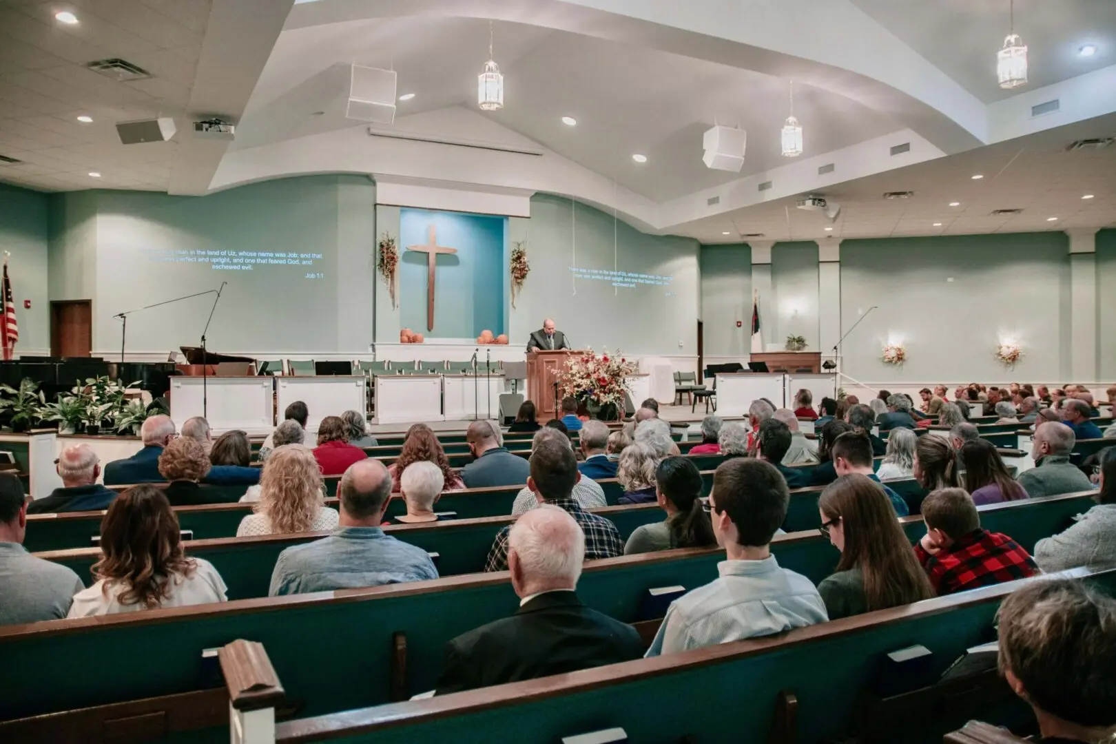 We clean religious spaces. Image of a church service with congregation and pastor speaking.