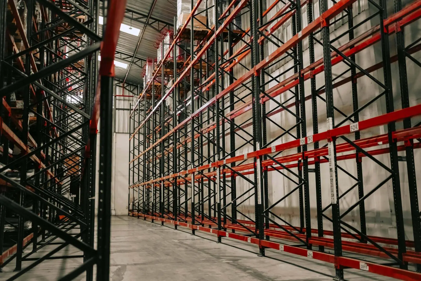 We service industrial facilities. Image of warehouse with metal storage racks and concrete floors.