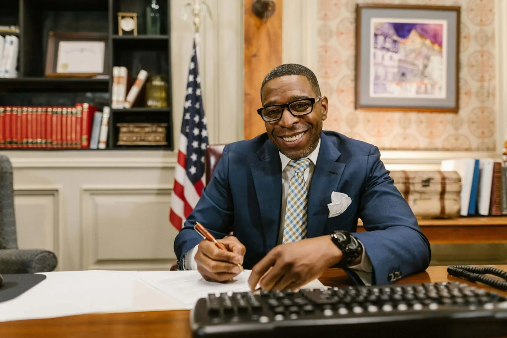 We clean government offices. Image of smiling public servant writing at office desk.